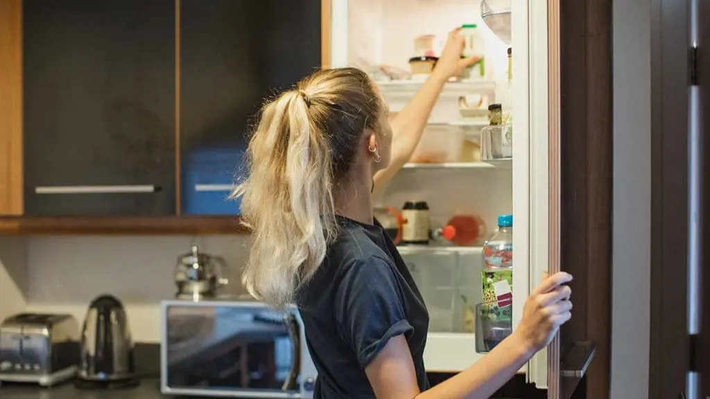 woman open fridge