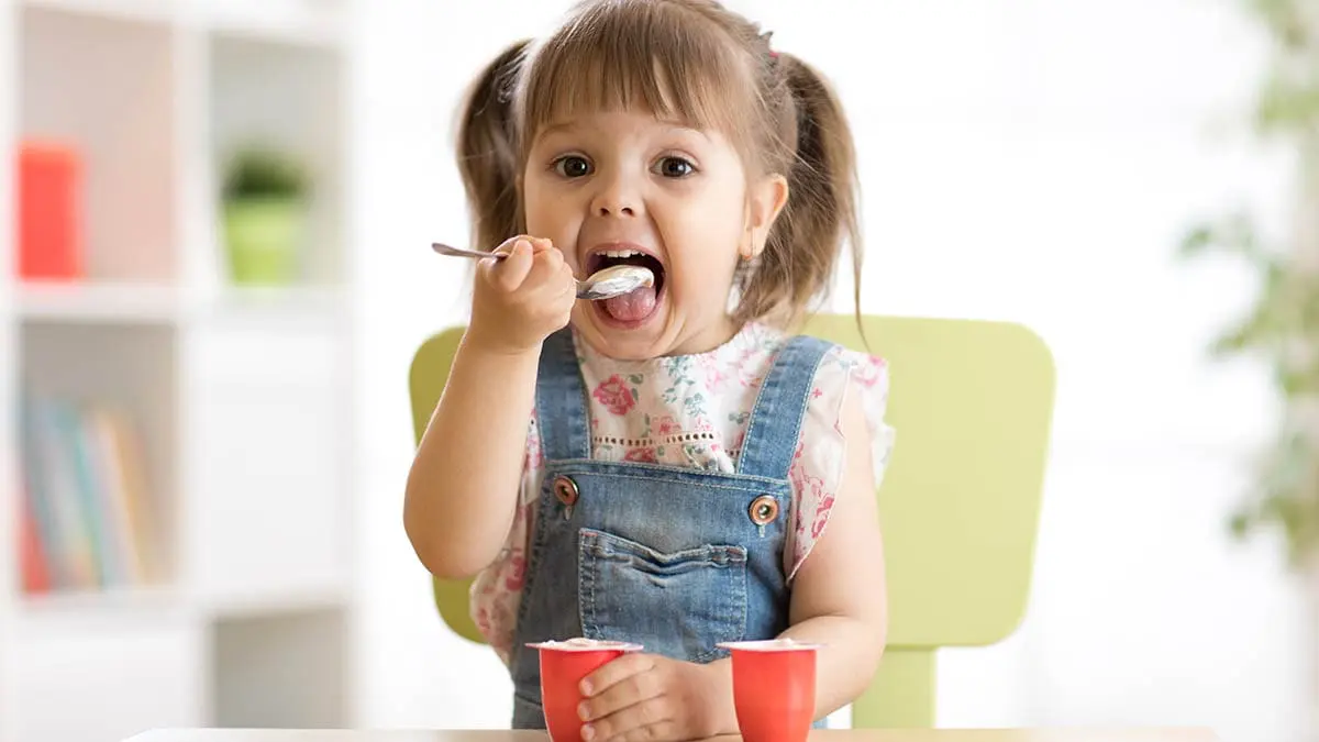 child eating yogurt