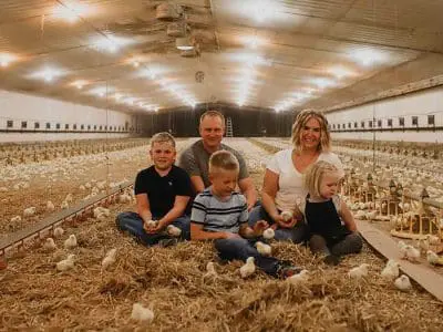 farm family in chick barn